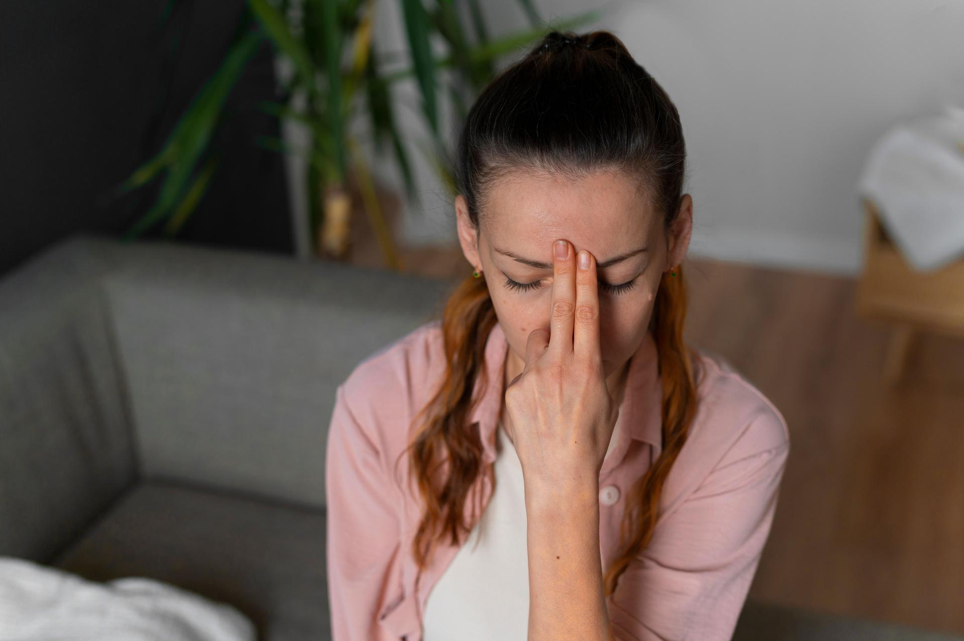 Femme pratiquant l'EFT (Emotional Freedom Technique), en tapotant des points spécifiques sur son visage pour réduire le stress et libérer des émotions